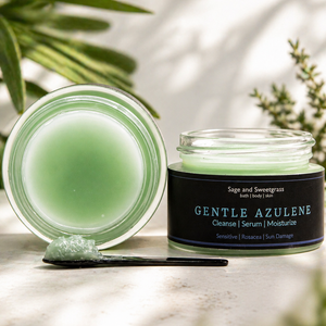 A 30ml jar of a aqua color serum sititng on a marble bench. A spoon sits in front showing the texture of the product.