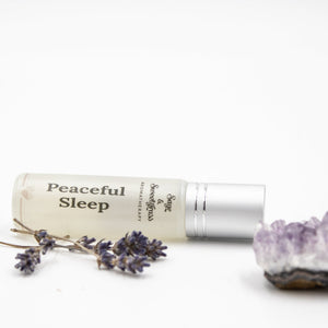 Roll-on bottle labeled 'Peaceful Sleep' with lavender flowers and a crystal on a white background